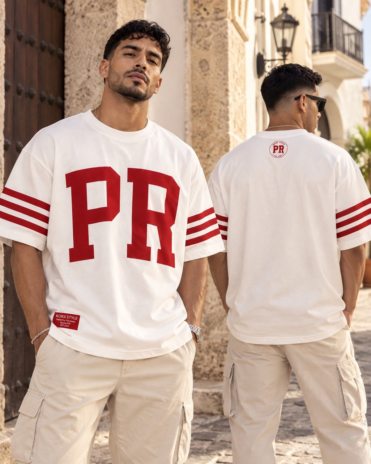 Two men wearing the white and red Men's PR Varsity Stripe Tee by Kokii Style in Old San Juan – front and back view