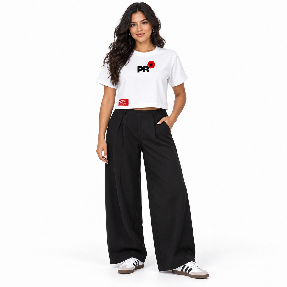 Woman wearing the Kokii Style PR Flor de Maga Crop Top in white with black wide-leg trousers and sneakers – front view, Puerto Rico streetwear